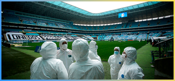 Profissionais da saúde com roupas contra contaminação analisando as conidições da Arena do Grêmio